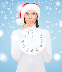 Image showing woman in santa helper hat with clock showing 12