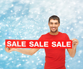 Image showing smiling man in red shirt with sale sign