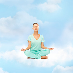 Image showing girl sitting in lotus position and meditating