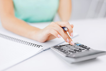 Image showing businesswoman working with calculator in office