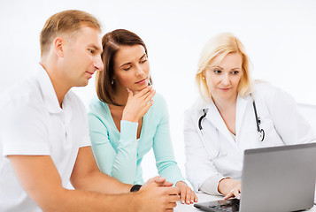 Image showing doctor with patients looking at laptop