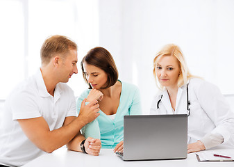 Image showing doctor with patients looking at laptop