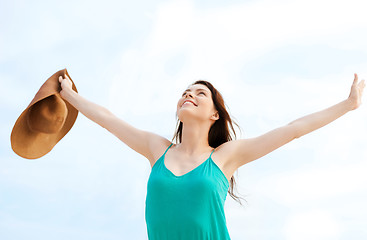 Image showing girl with hands up on the beach