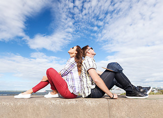 Image showing teenagers sitting back to back