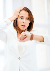 Image showing stressed businesswoman looking at clock