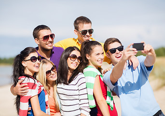 Image showing group of friends taking picture with smartphone