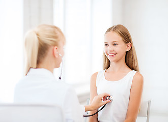 Image showing doctor with stethoscope listening to the patient