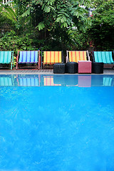 Image showing Deck chairs next to a pool