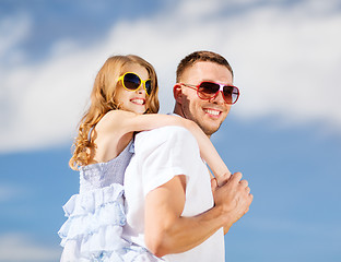 Image showing happy father and child in sunglasses over blue sky