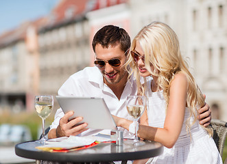 Image showing couple looking at tablet pc in cafe