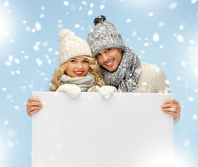 Image showing couple in a winter clothes holding blank board