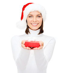 Image showing smiling woman in santa hat with small gift box