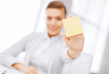 Image showing smiling businesswoman showing sticky note