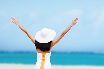 Image showing girl with hands up on the beach