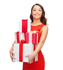 Image showing smiling woman in red dress with many gift boxes