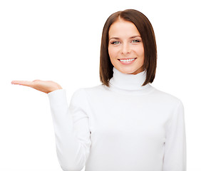 Image showing woman in white sweater with something on palm