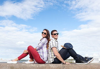 Image showing teenagers sitting back to back