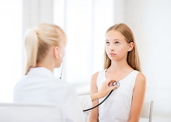 Image showing doctor with stethoscope listening to the patient