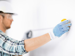 Image showing architect measuring wall with flexible ruler