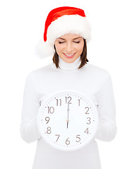Image showing woman in santa helper hat with clock showing 12