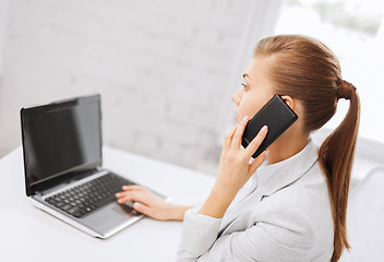 Image showing businesswoman with smartphone in office