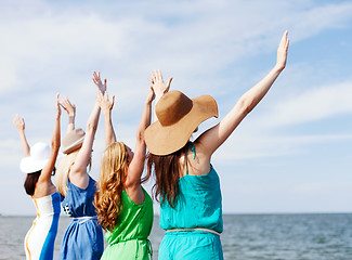 Image showing girls looking at the sea with hands up