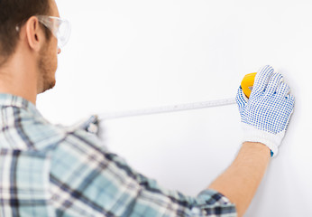 Image showing architect measuring wall with flexible ruler