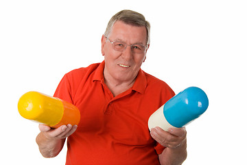 Image showing Old man holding big pills