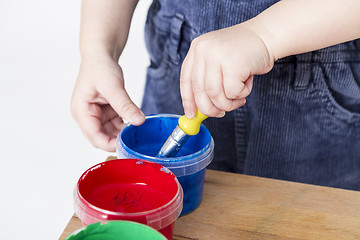 Image showing child holding brush in paint tub