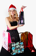 Image showing Blond woman in santa hat with shopping bags