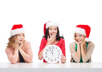 Image showing women in santa helper hats with clock showing 12