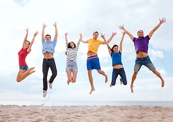 Image showing group of friends jumping on the beach