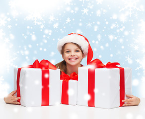 Image showing girl in santa helper hat with many gift boxes