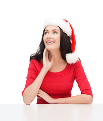 Image showing surprised woman in santa helper hat looking up