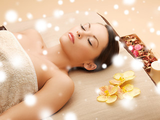 Image showing woman in spa salon lying on the massage desk