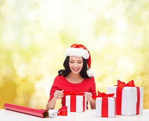 Image showing woman in santa helper hat with many gift boxes