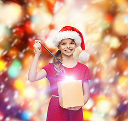 Image showing smiling girl in santa helper hat with gift box