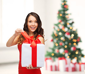 Image showing smiling woman in red dress with gift box