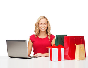 Image showing woman with gift boxes, bags and laptop computer