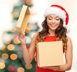 Image showing smiling woman in santa helper hat with gift box