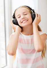 Image showing little girl with headphones at home