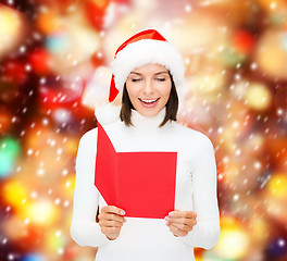 Image showing woman in santa helper hat with blank red postcard