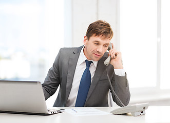 Image showing businessman with laptop computer and phone