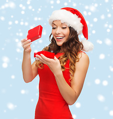 Image showing smiling woman in santa helper hat with gift box