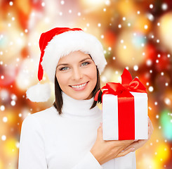 Image showing smiling woman in santa helper hat with gift box