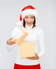 Image showing surprised woman in santa helper hat with gift box