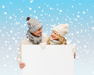 Image showing couple in winter clothes with blank white board