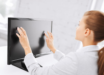 Image showing smiling businesswoman with touchscreen in office