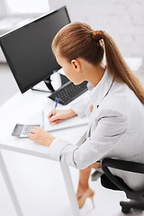 Image showing businesswoman with notebook and calculator