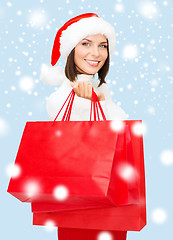 Image showing woman in santa helper hat with shopping bags